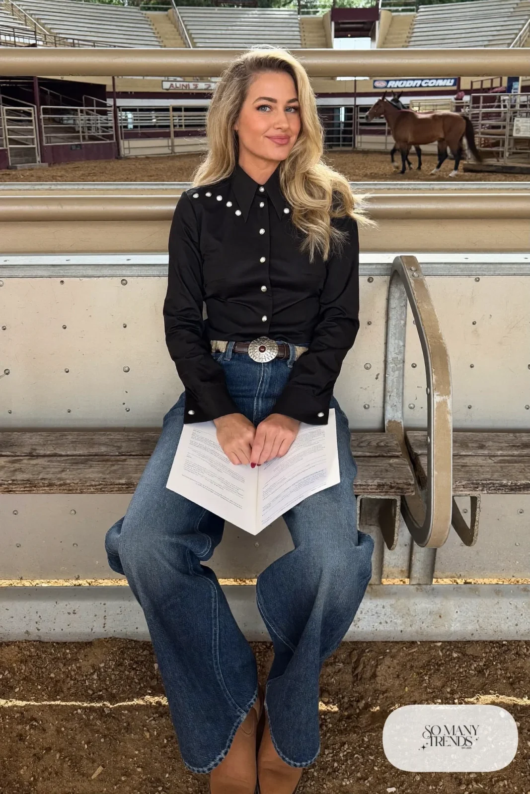 Woman in black pearl-snap western shirt, wide-leg blue jeans, concho belt and cowboy boots, outfit 4