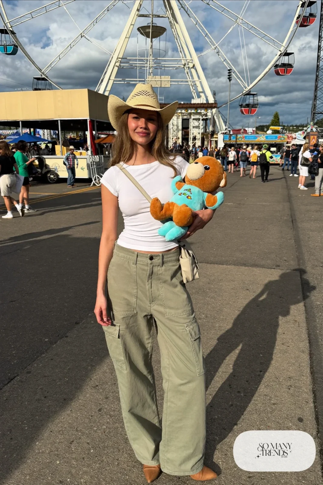 Woman in sage green cargo pants, white tee, straw hat and tan boots, outfit 9
