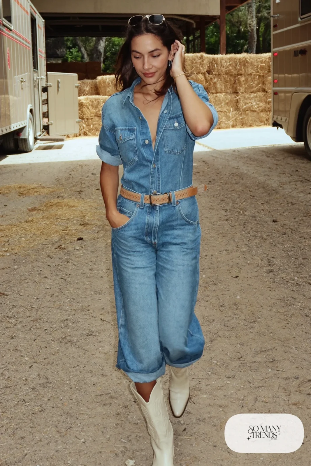 Woman in wide-leg chambray denim jumpsuit with belt and cream cowboy boots, outfit 11