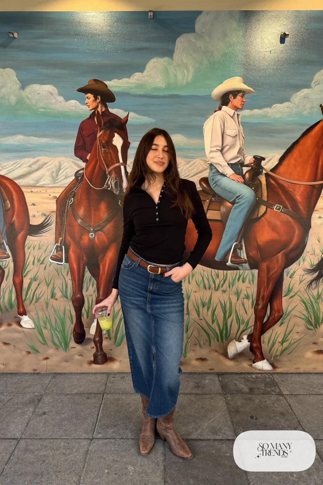 Woman in mid-length denim skirt with slit, black long-sleeve tee and brown boots, outfit 20