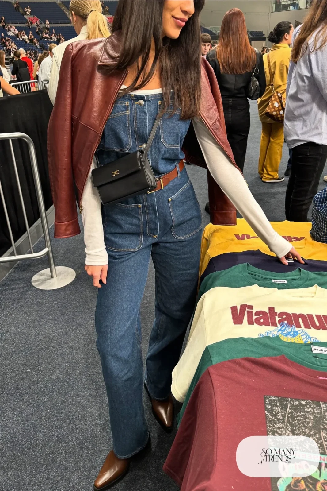 Woman in a denim jumpsuit, cognac cropped leather jacket, white long-sleeve tee and brown boots, concert outfit 6