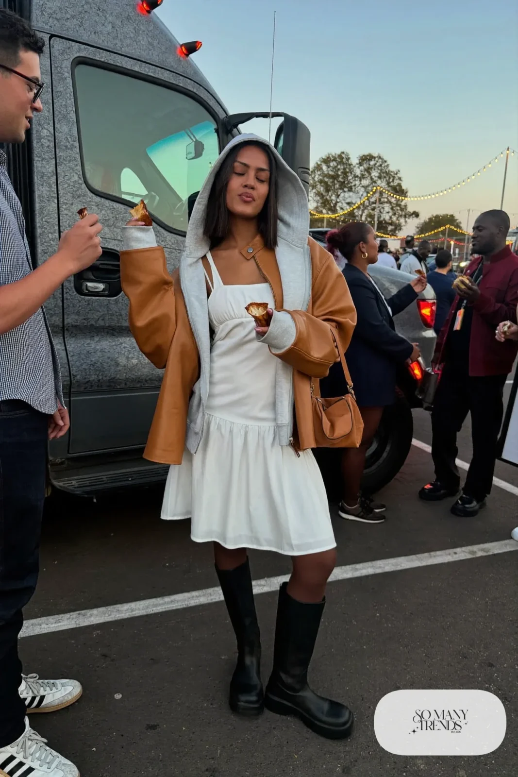 Woman in a white slip dress, gray zip hoodie, tan leather jacket, tights and chunky knee-high boots, concert outfit 32