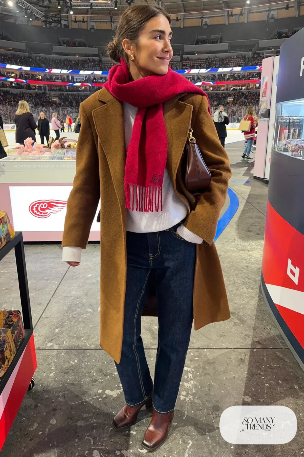 Woman in camel wool coat, cranberry red oversized scarf, dark jeans, white knit sweater and brown ankle boots, hockey game outfit 8