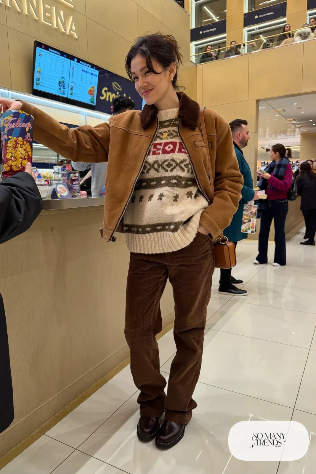Woman in chunky Fair Isle sweater, brown corduroy straight pants, shearling jacket and brown lug-sole boots, hockey game outfit 25
