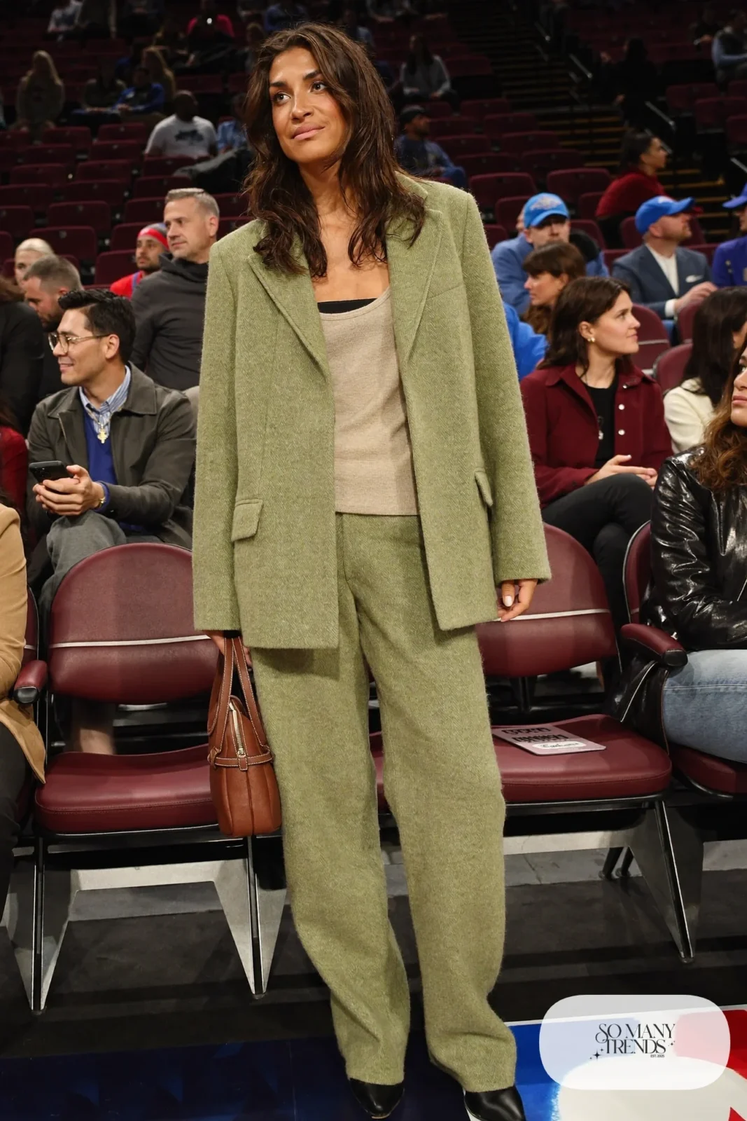 Woman in a sage green blazer and matching straight pants with an oatmeal knit tank and black boots, basketball game outfit 3