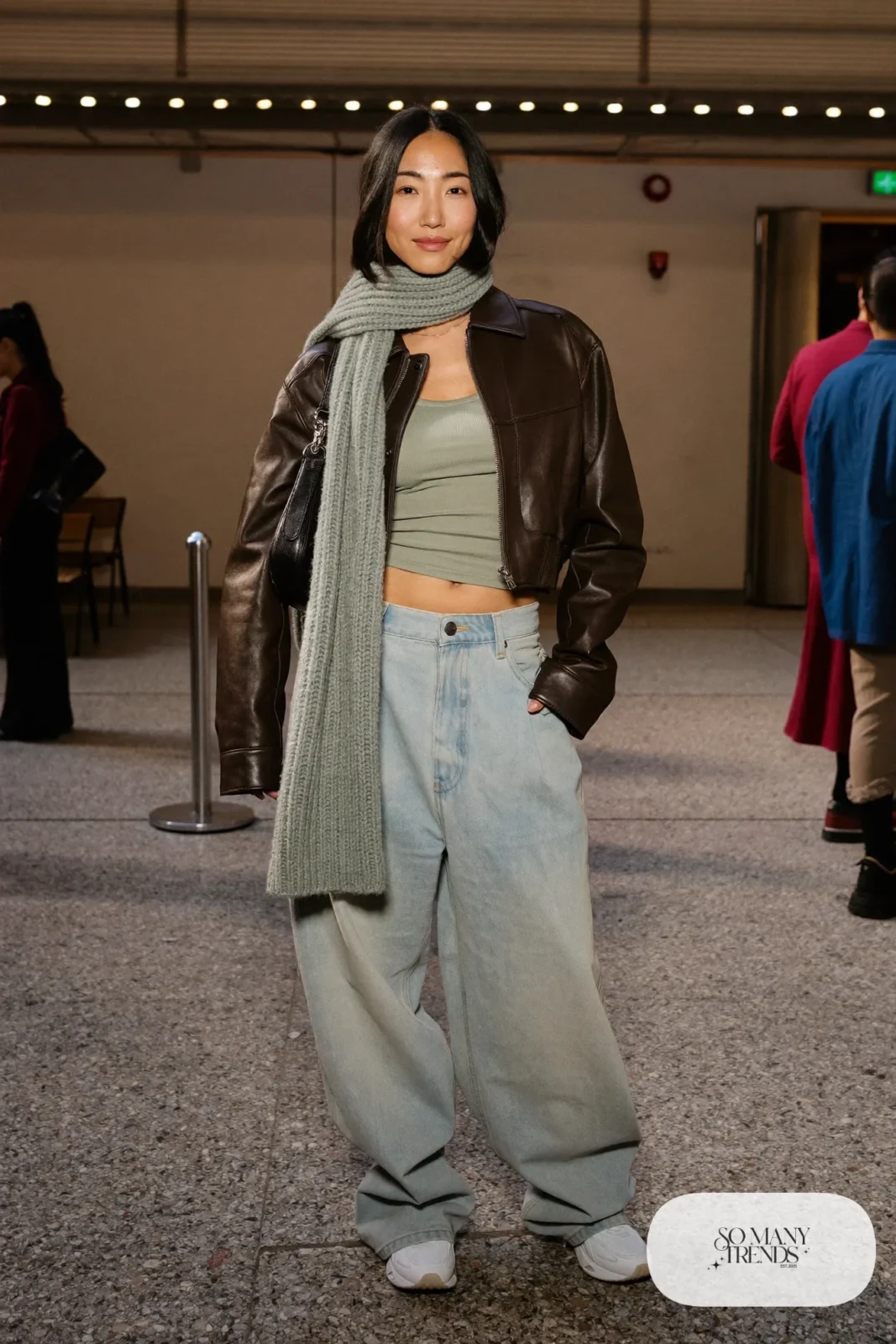 Woman in baggy light jeans, fitted ribbed tank, cropped leather jacket and chunky sneakers, basketball game outfit 24
