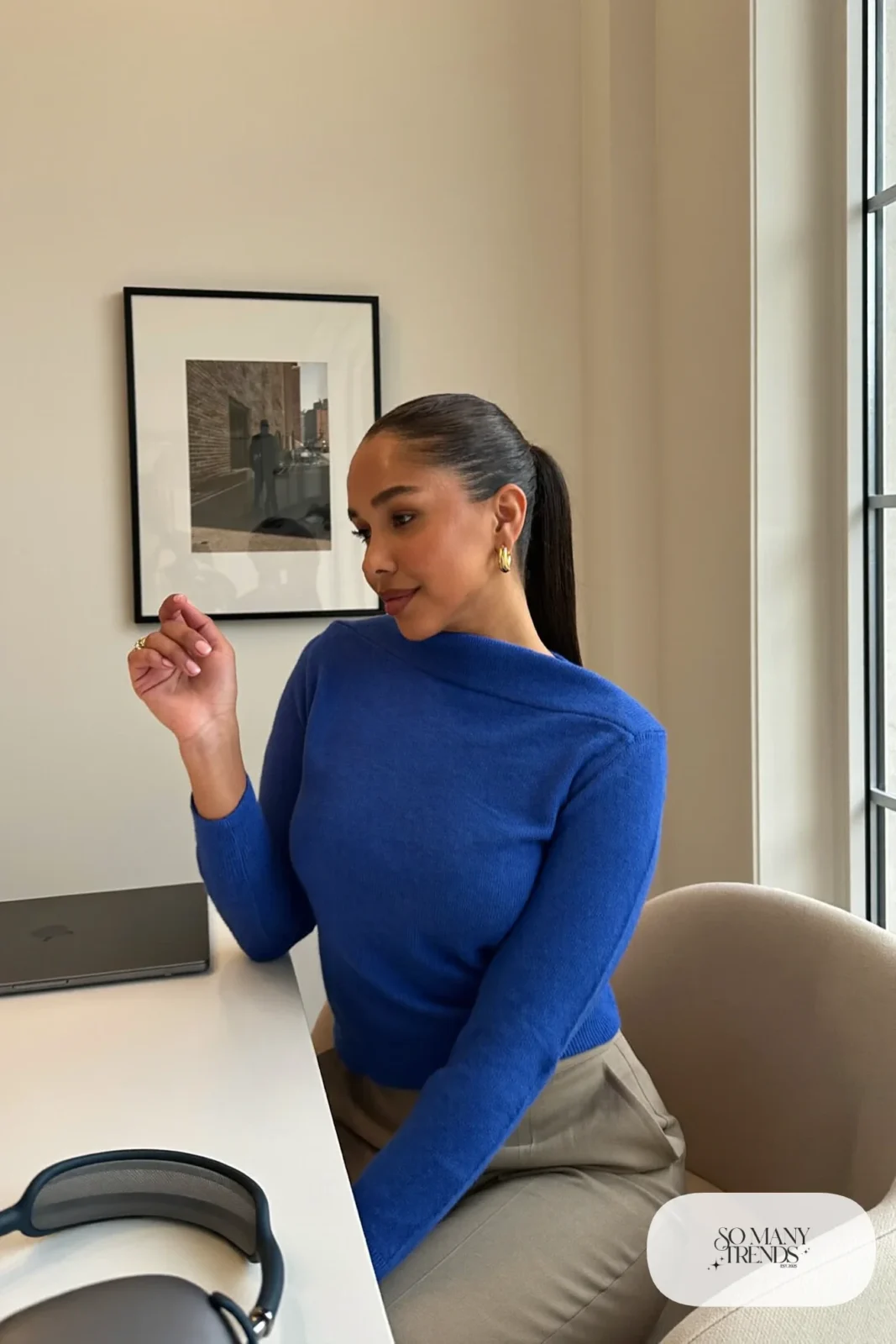 cobalt blue fine knit boat neck sweater with small gold hoops seated at a desk, interview outfit 24