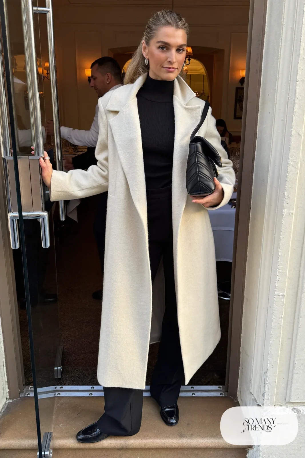 cream funnel-neck cocoon coat over black turtleneck and black wide pants with black loafers, interview outfit 28