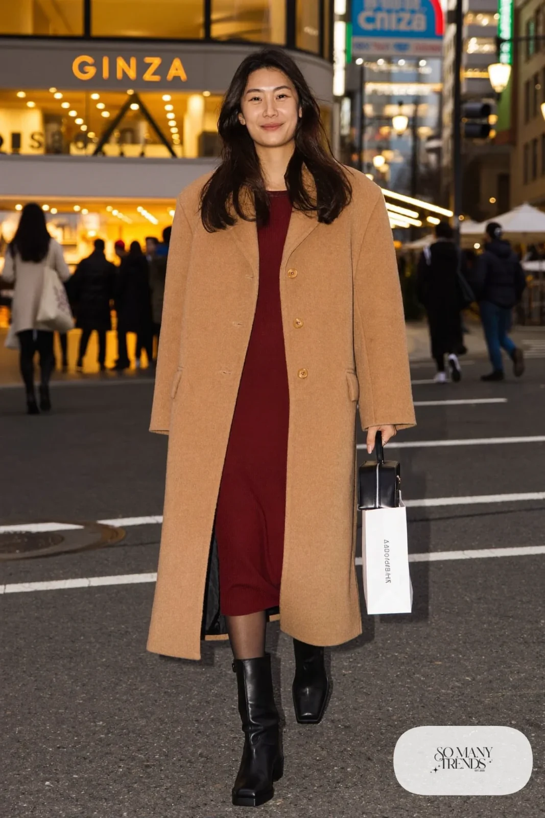 Woman in a camel boxy coat open over a burgundy knit midi dress with black tall boots and a black bag, outfit 4