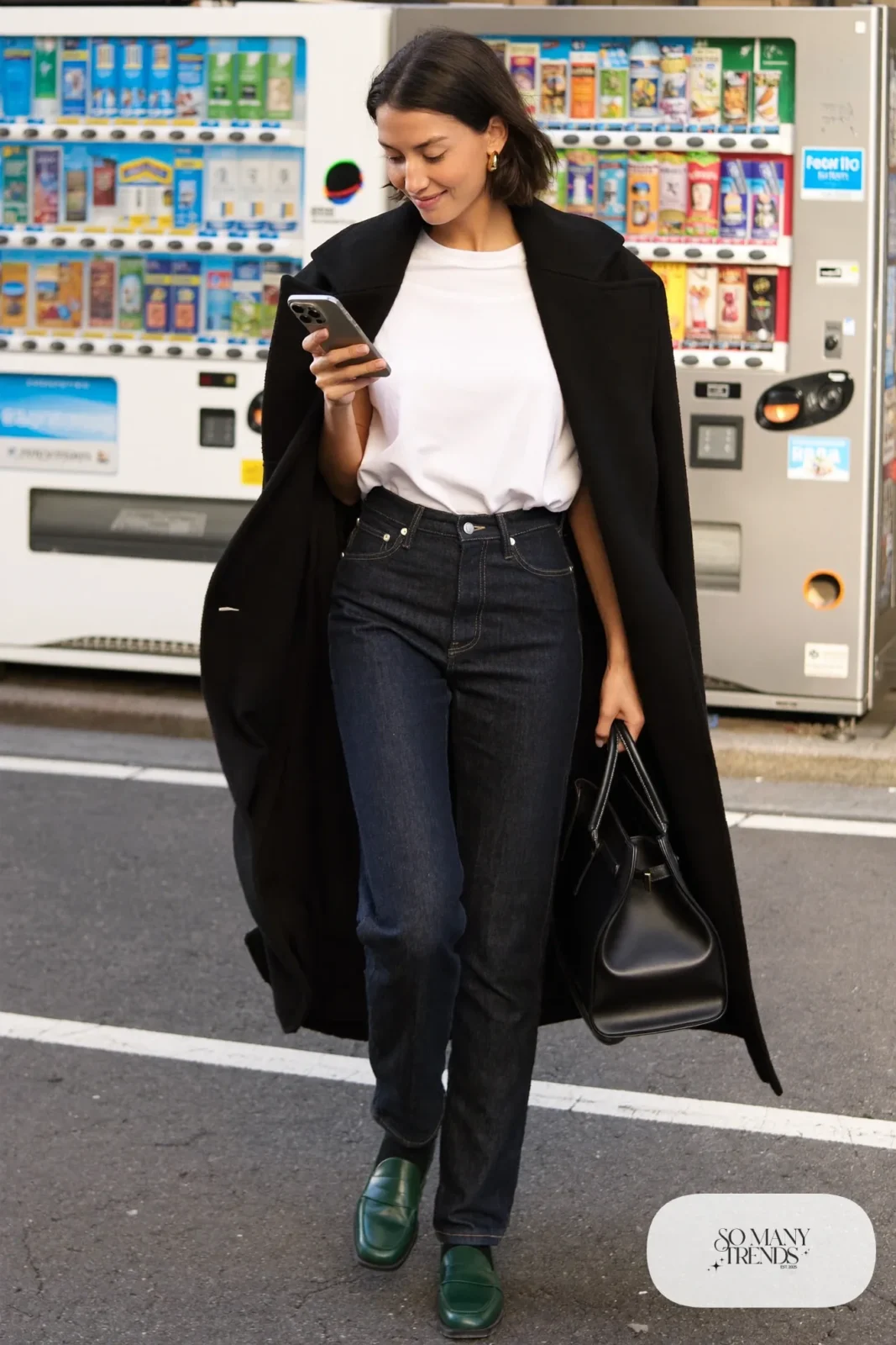 Woman in a black wool cape coat, dark straight jeans, a white tee and emerald loafers on a Tokyo sidewalk, outfit 7