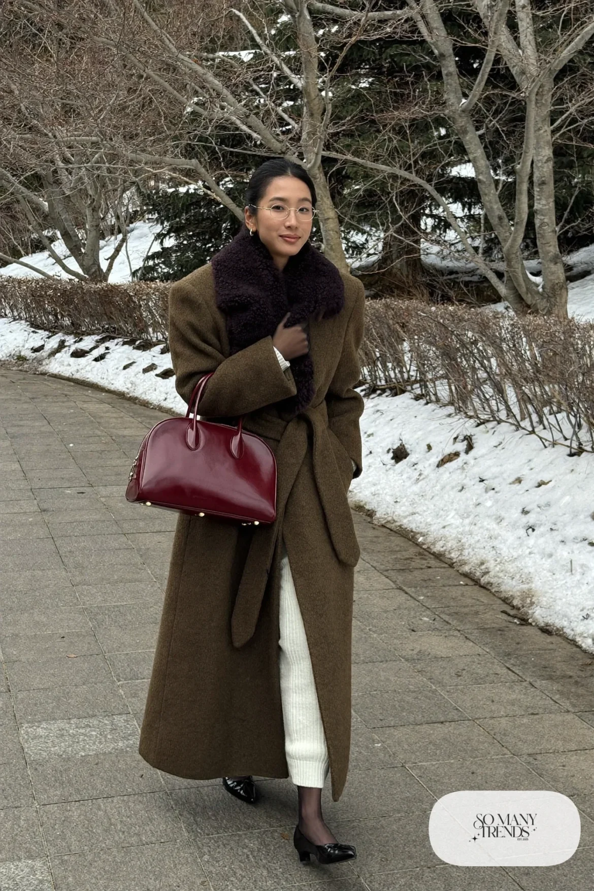 Woman in a long olive coat with a shaggy shearling collar over a white ribbed knit maxi dress with black flats and a red-burgundy bag, outfit 10