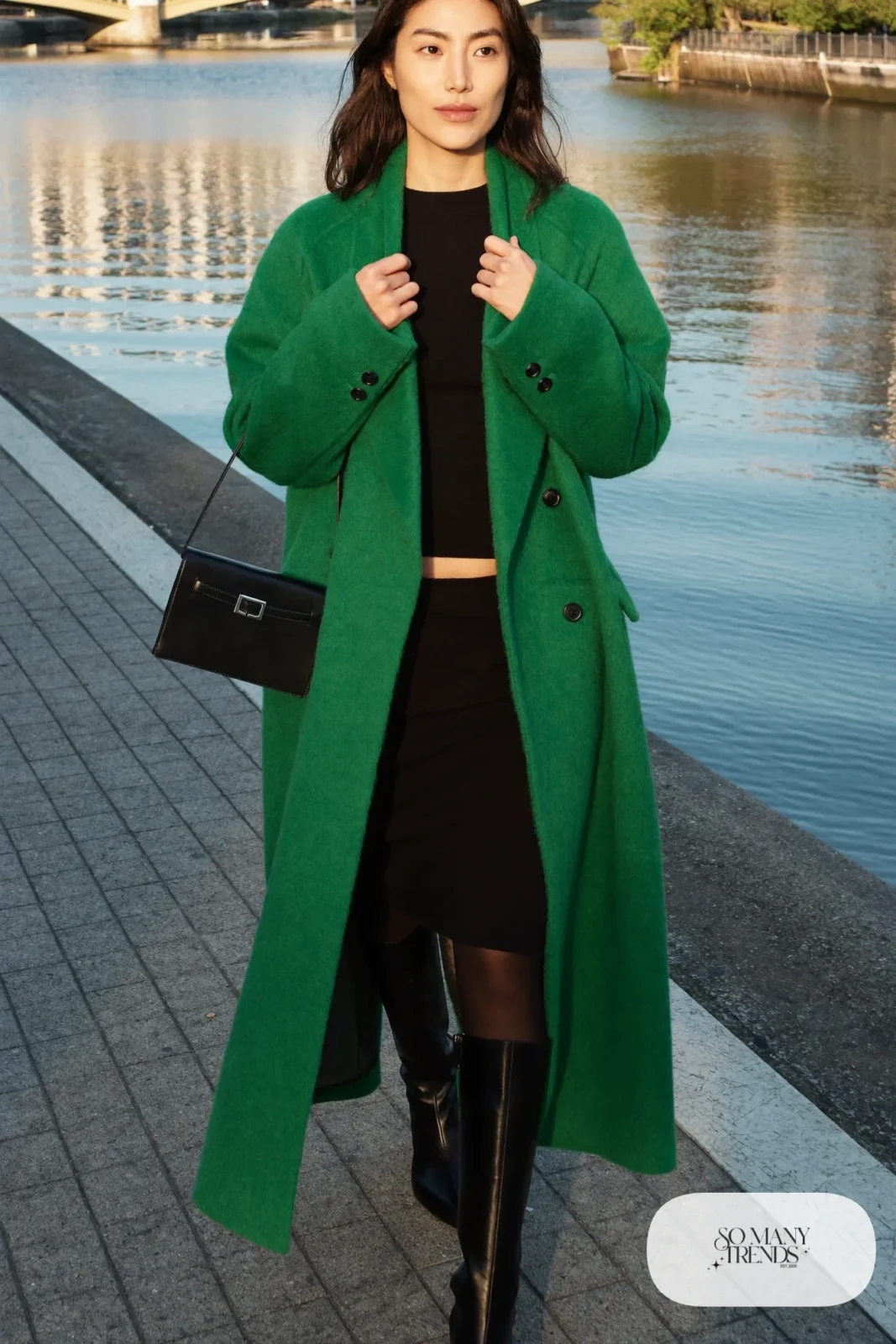 Woman in an emerald wool coat over a black fine knit top and midi skirt set with tall black boots in Kyoto, outfit 28