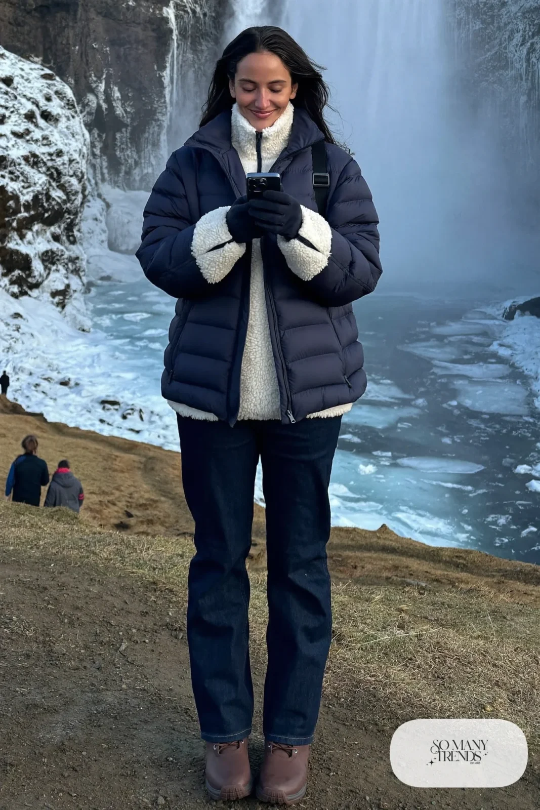 Woman in a navy quilted jacket, cream fleece, dark straight jeans and waterproof boots at Gullfoss, outfit 10