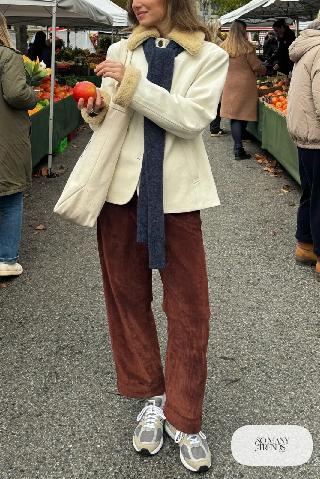 Woman in cream shearling jacket, chocolate brown corduroy pants, indigo scarf and gray New Balance 9060 sneakers, outfit 8