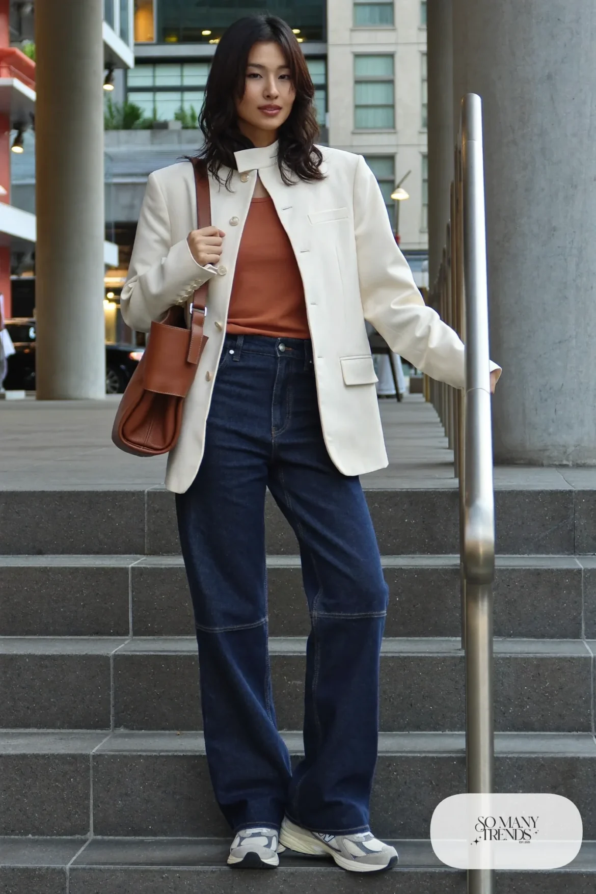 Woman in cream wrap blazer, terracotta tank, flared indigo jeans and gray New Balance 9060 sneakers, outfit 9