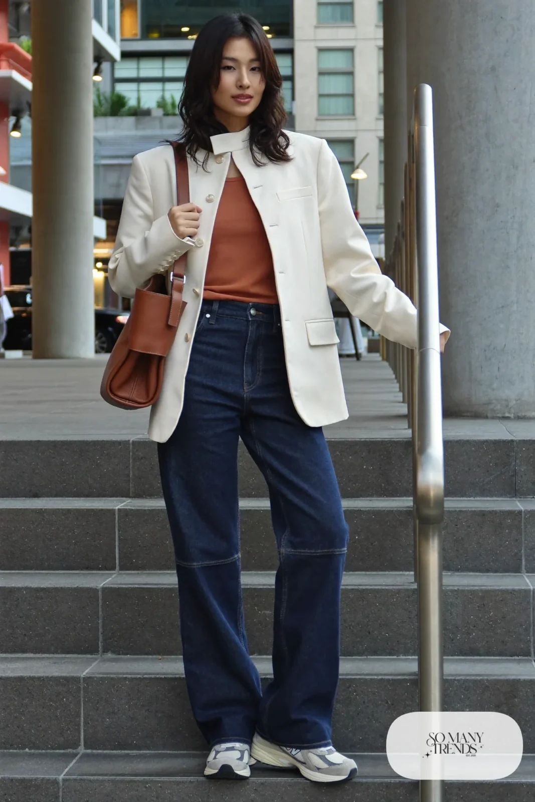 Woman in cream wrap blazer, terracotta tank, flared indigo jeans and gray New Balance 9060 sneakers, outfit 9