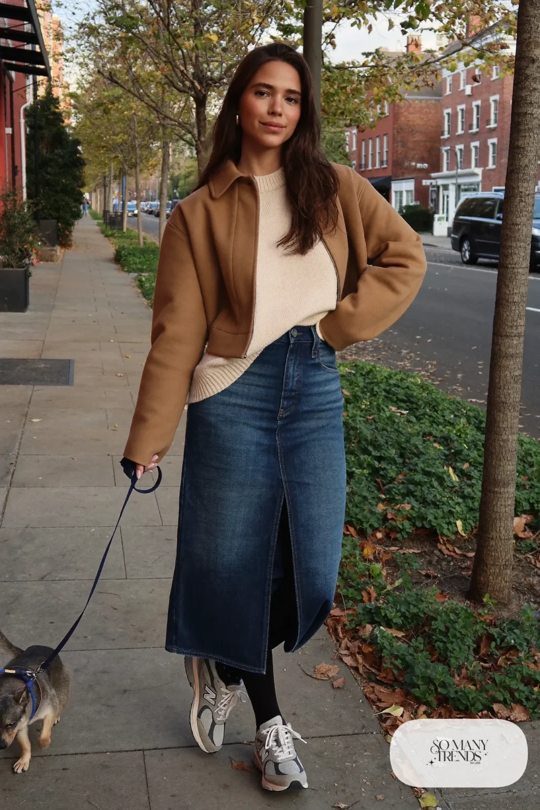 Woman in long indigo denim skirt, oversized cream sweater, black tights and gray New Balance 9060 sneakers, outfit 15