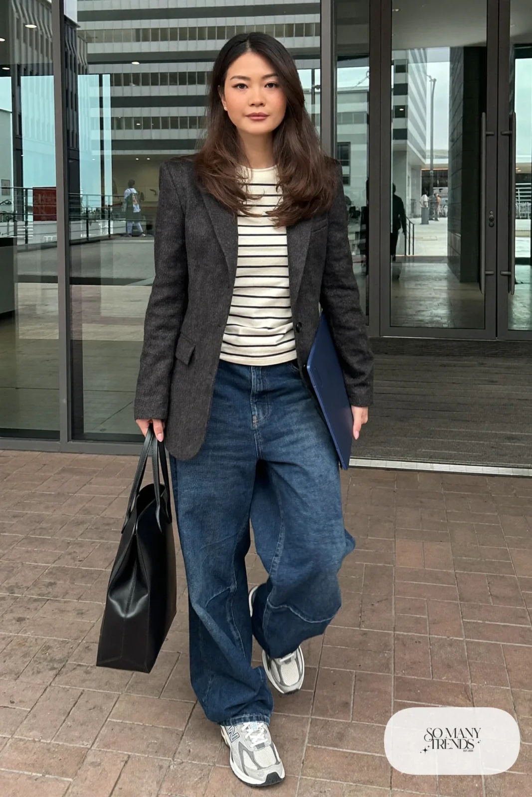 Woman in charcoal tailored blazer, striped tee, baggy indigo jeans and gray New Balance 9060 sneakers, outfit 18