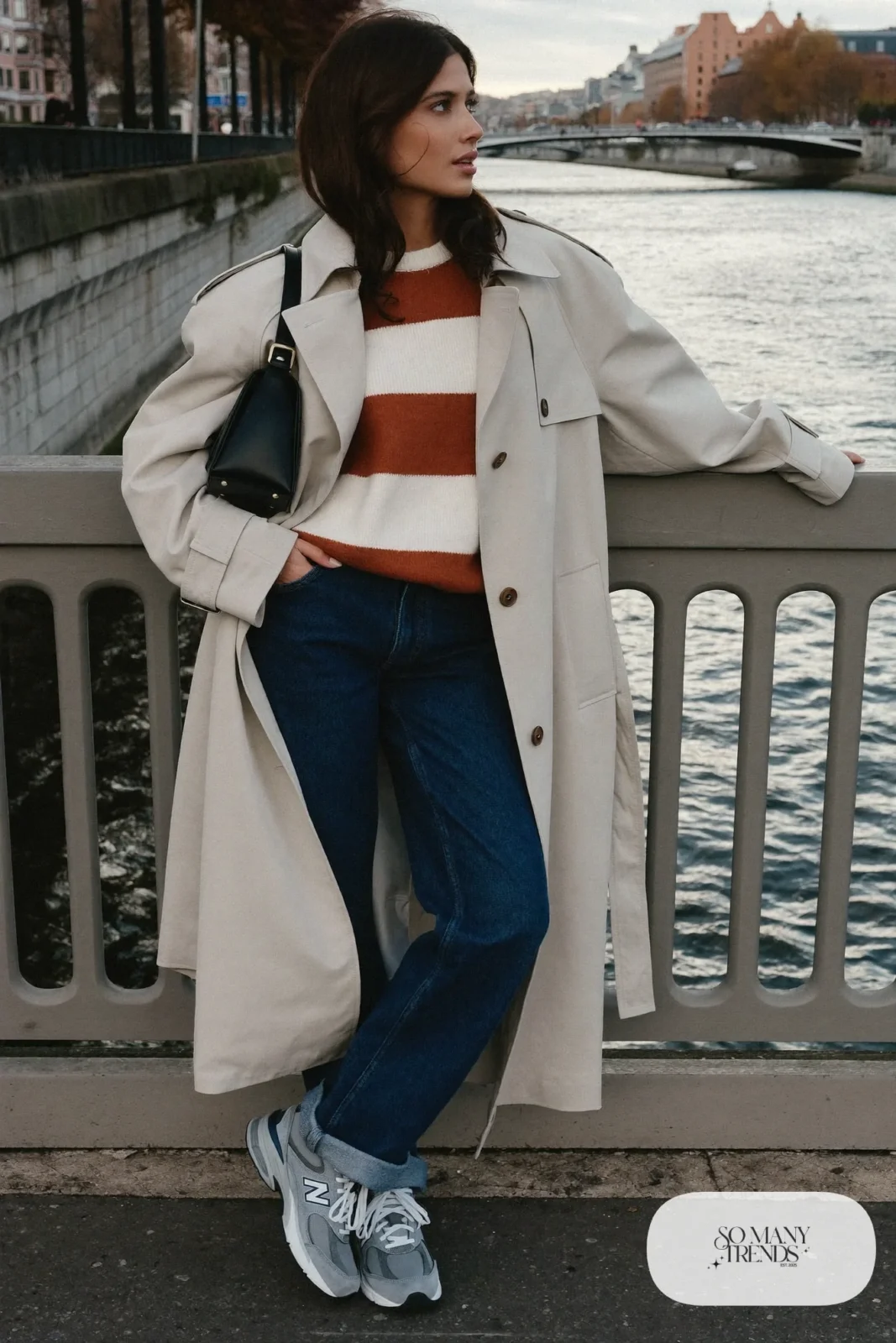 Woman in beige trench, striped knit sweater, indigo jeans and gray New Balance 9060 sneakers, outfit 21