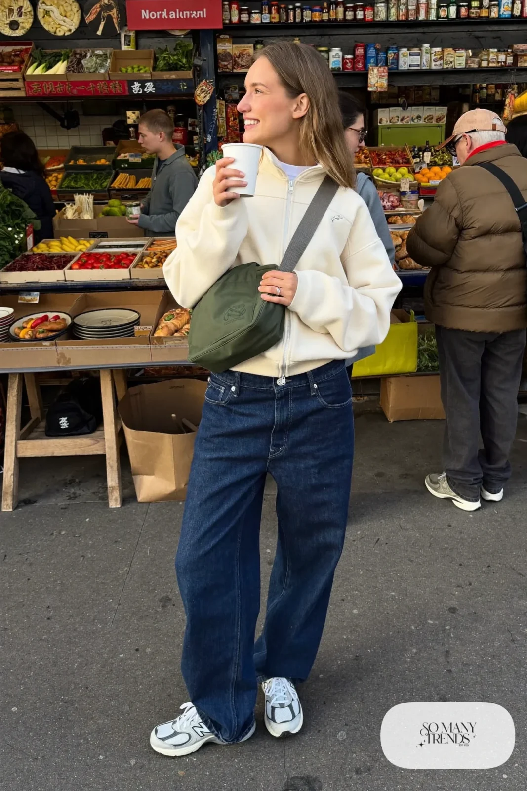 Woman in cream fleece zip-up, wide indigo jeans and gray New Balance 9060 sneakers, outfit 26