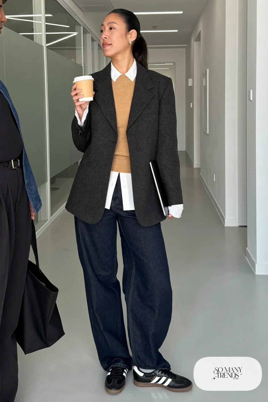 Charcoal tailored blazer, camel knit vest over white shirt, dark indigo wide-leg jeans and black Adidas Samba sneakers, outfit 4