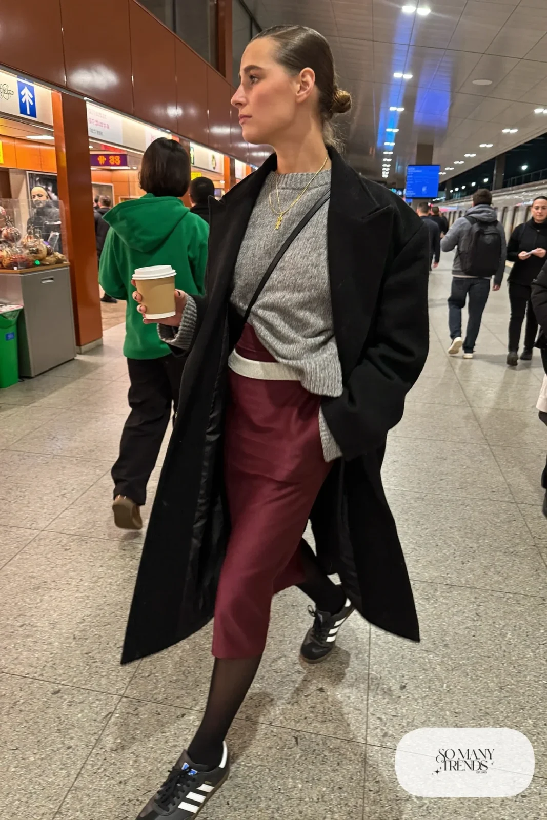 Long black wool coat, gray chunky sweater, burgundy satin midi skirt, black opaque tights and black Adidas Samba sneakers, outfit 6
