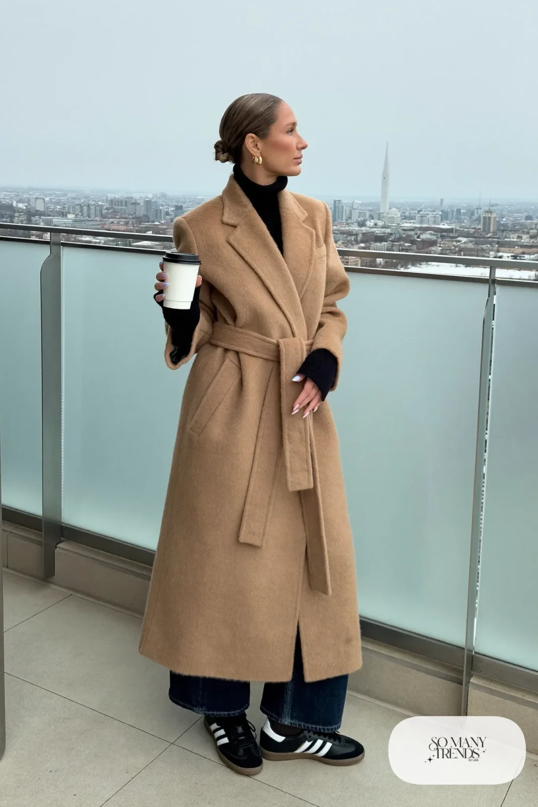 Tan wool wrap coat, black knit sweater, dark barrel-leg jeans and black Adidas Samba sneakers, outfit 26