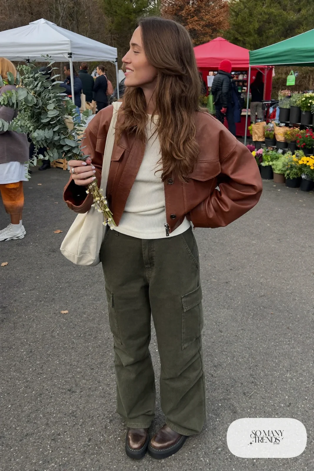 Woman in cognac leather jacket, cream tee, olive cargo pants and brown boots, outfit 5