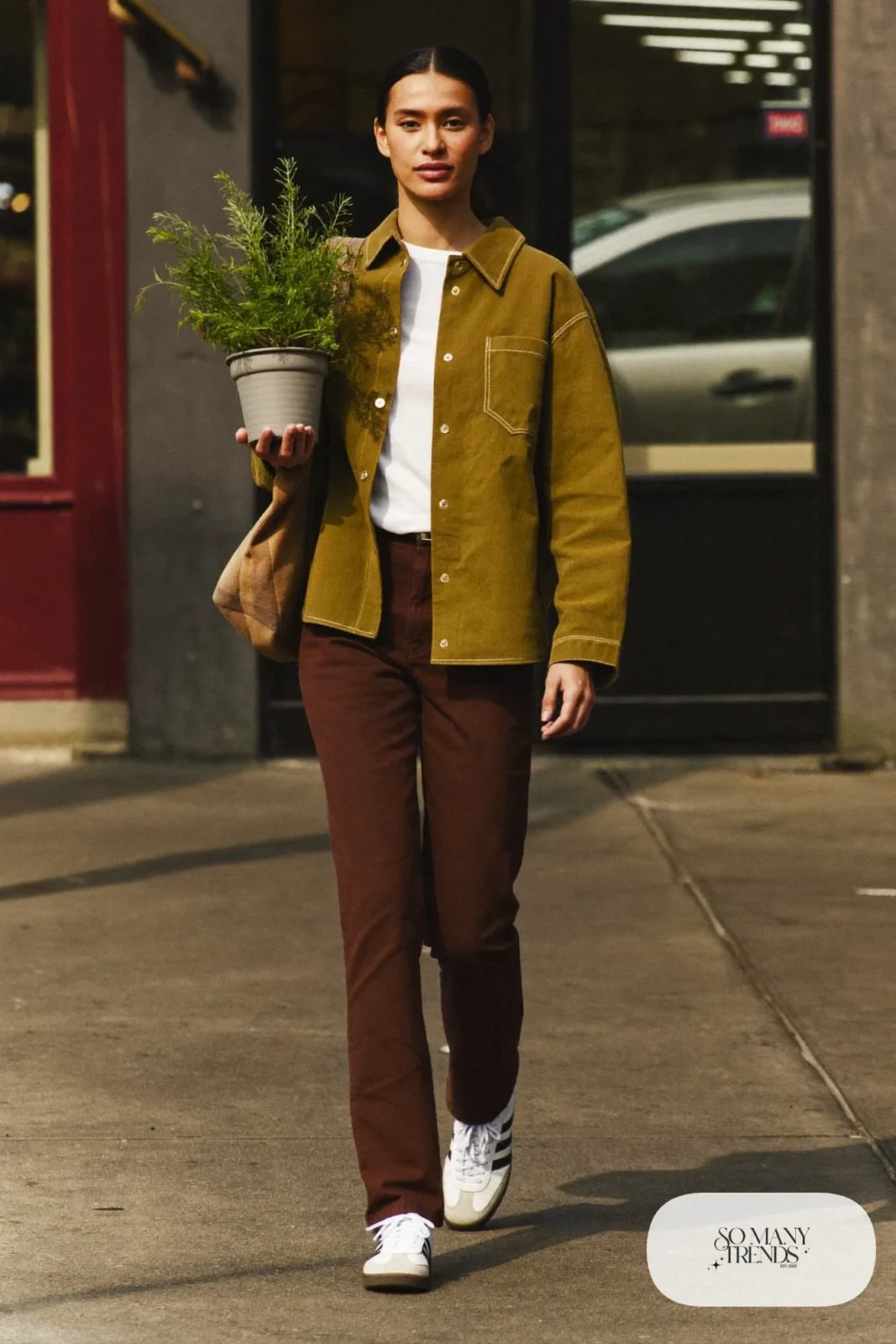 Woman in olive overshirt, white tee, chocolate straight jeans and white sneakers, outfit 23