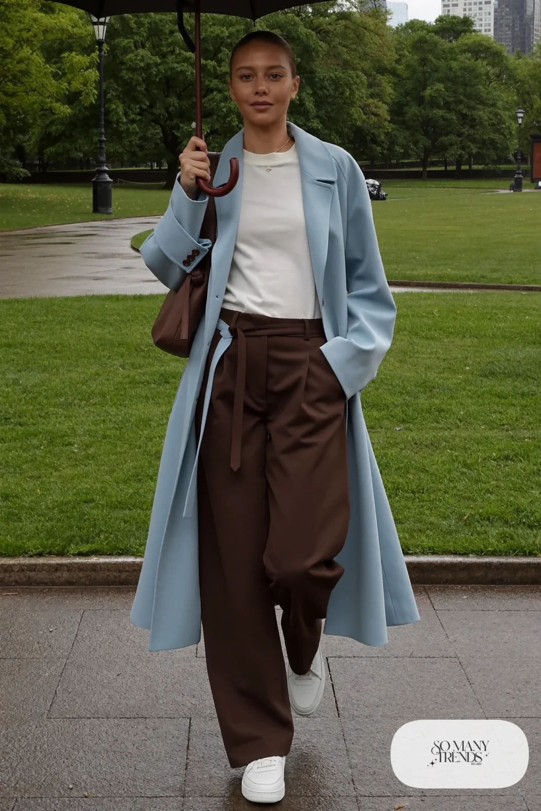 Light blue trench coat over a white tee and chocolate wide-leg pants with white leather sneakers, outfit 16