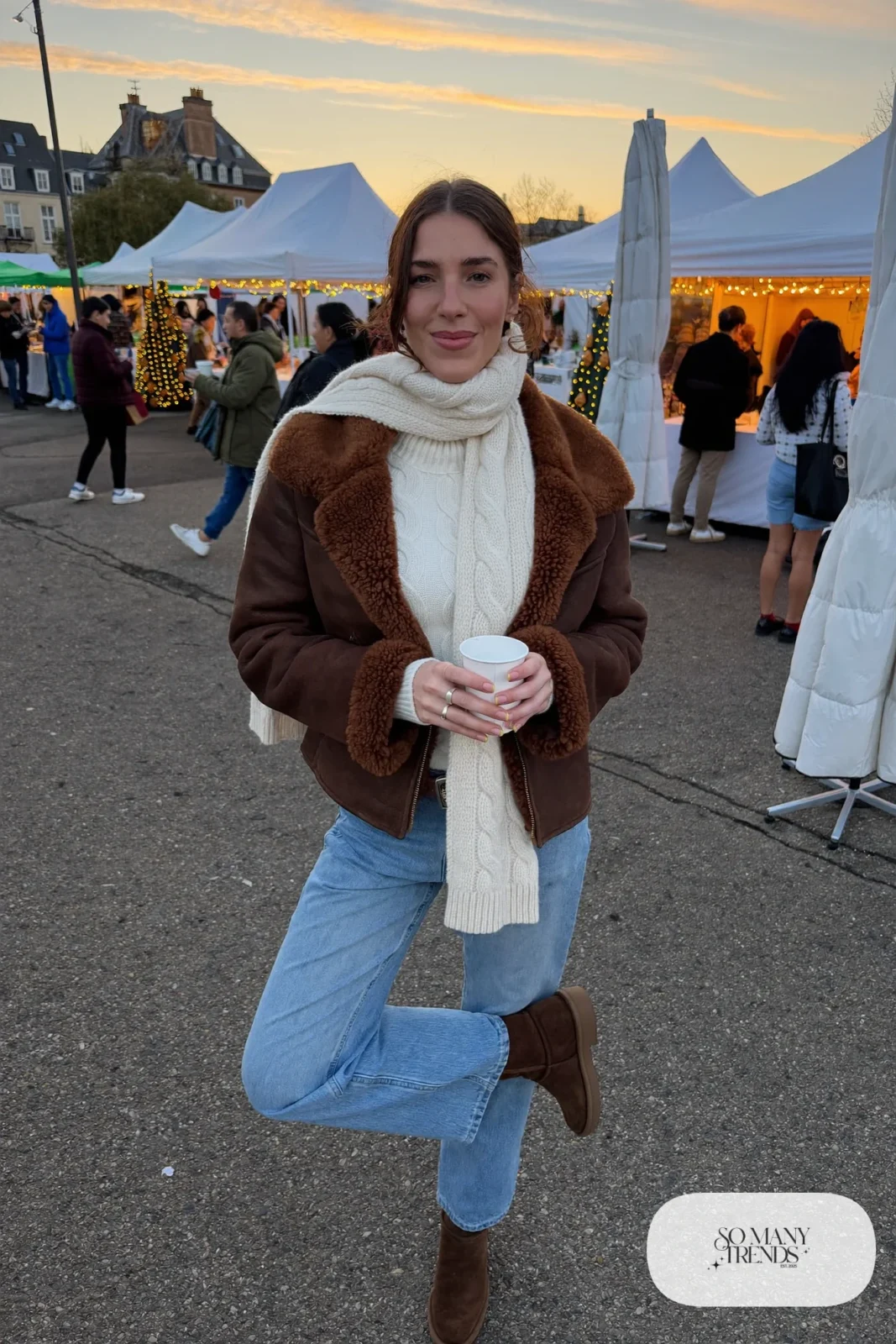 Brown shearling short jacket over a cream knit with pastel blue straight jeans and brown suede ankle boots, outfit 20