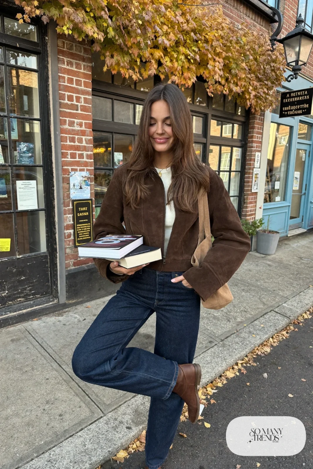 Woman in a chocolate suede jacket, cream tee, dark navy straight jeans and brown ankle boots, outfit 4