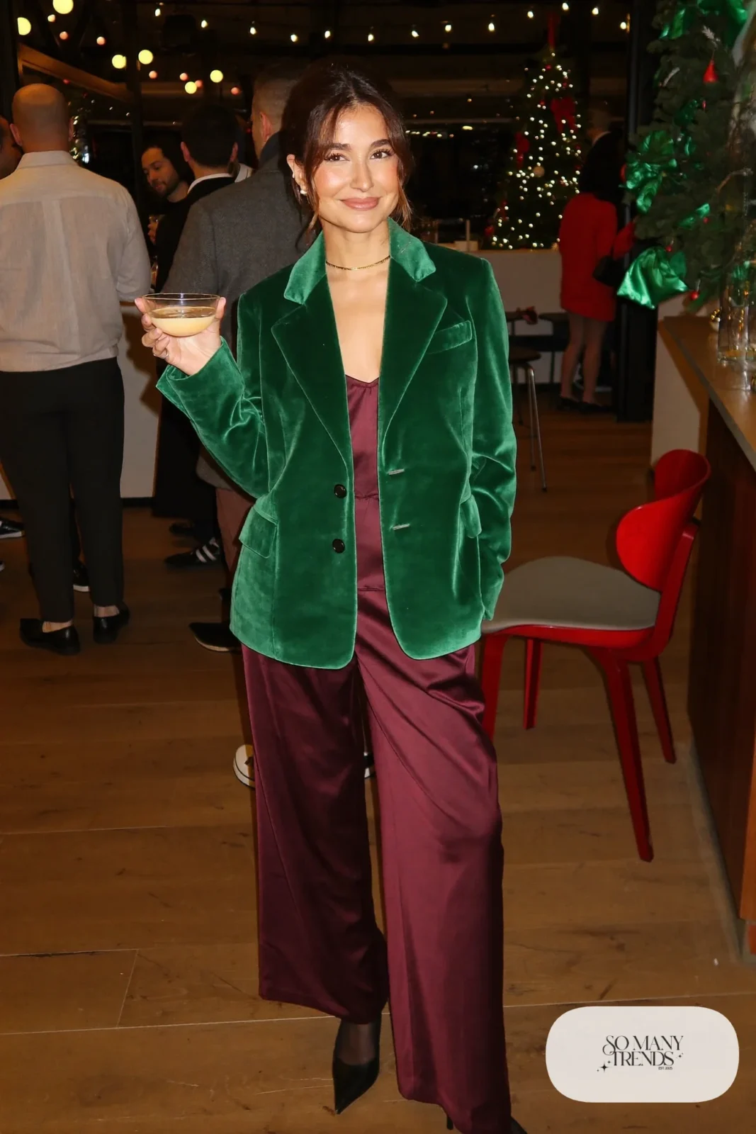 Woman in emerald velvet blazer, burgundy satin wide-leg pants, wine camisole and black pointed pumps, outfit 8