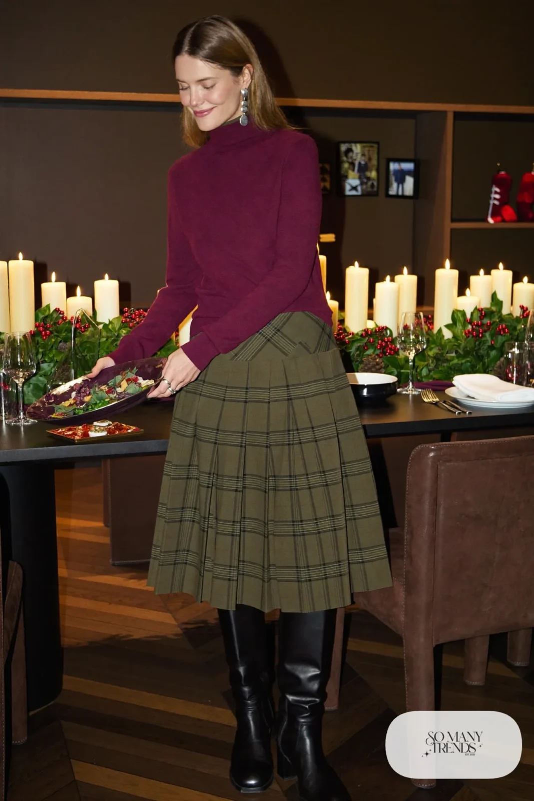 Woman in burgundy turtleneck, green plaid pleated midi skirt, black tights and tall black boots, outfit 14