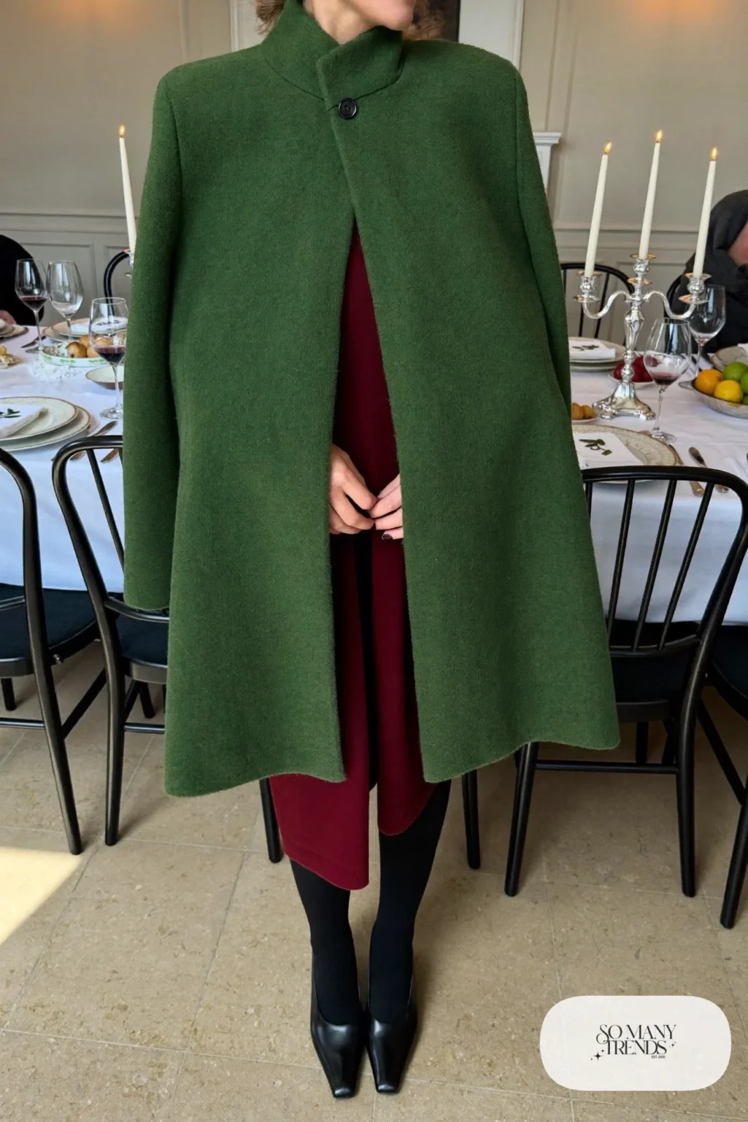 Woman in forest green wool cape, burgundy knee-length sheath dress, black tights and black pumps, outfit 23