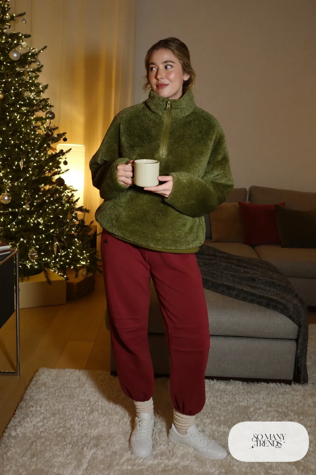 Woman in olive green sherpa pullover, burgundy fleece joggers, thick socks and white sneakers, outfit 24