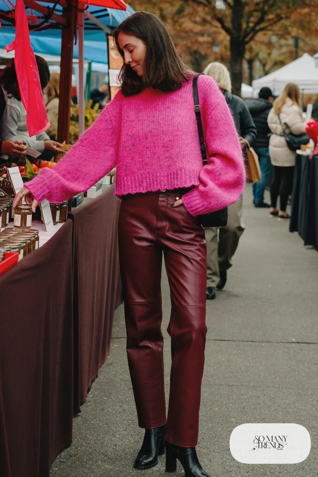 Woman in oversized bubblegum pink knit sweater, wine faux-leather straight pants and black ankle boots, outfit 3