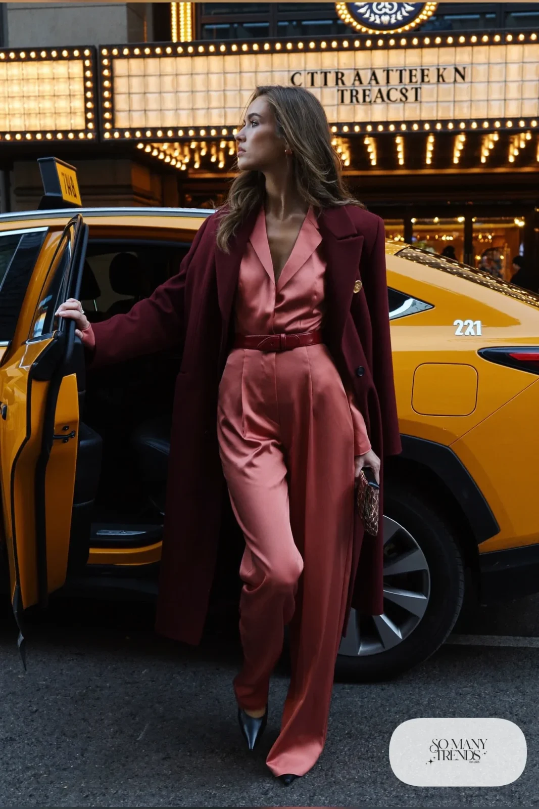 Woman in dusty-pink wide-leg jumpsuit, long wine wool coat, wine belt and black pointed pumps, outfit 22