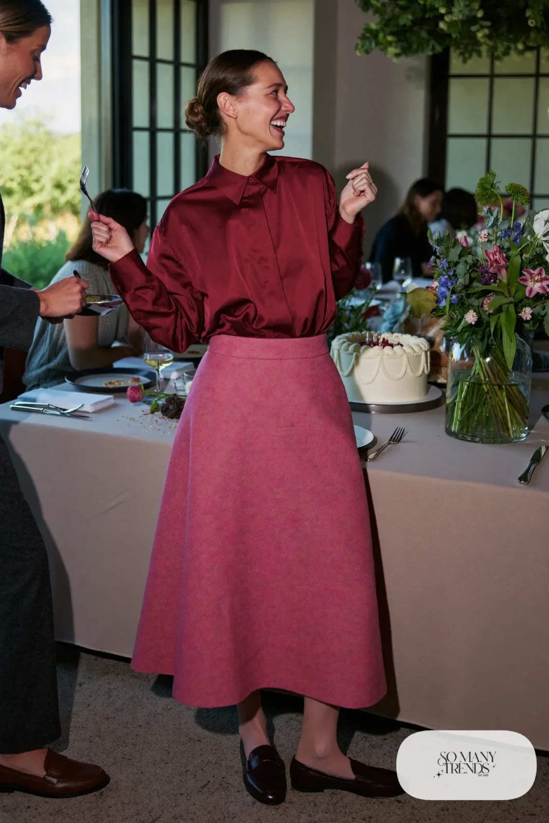 Woman in burgundy satin blouse, pink wool A-line midi skirt, sheer tights and brown loafers, outfit 30