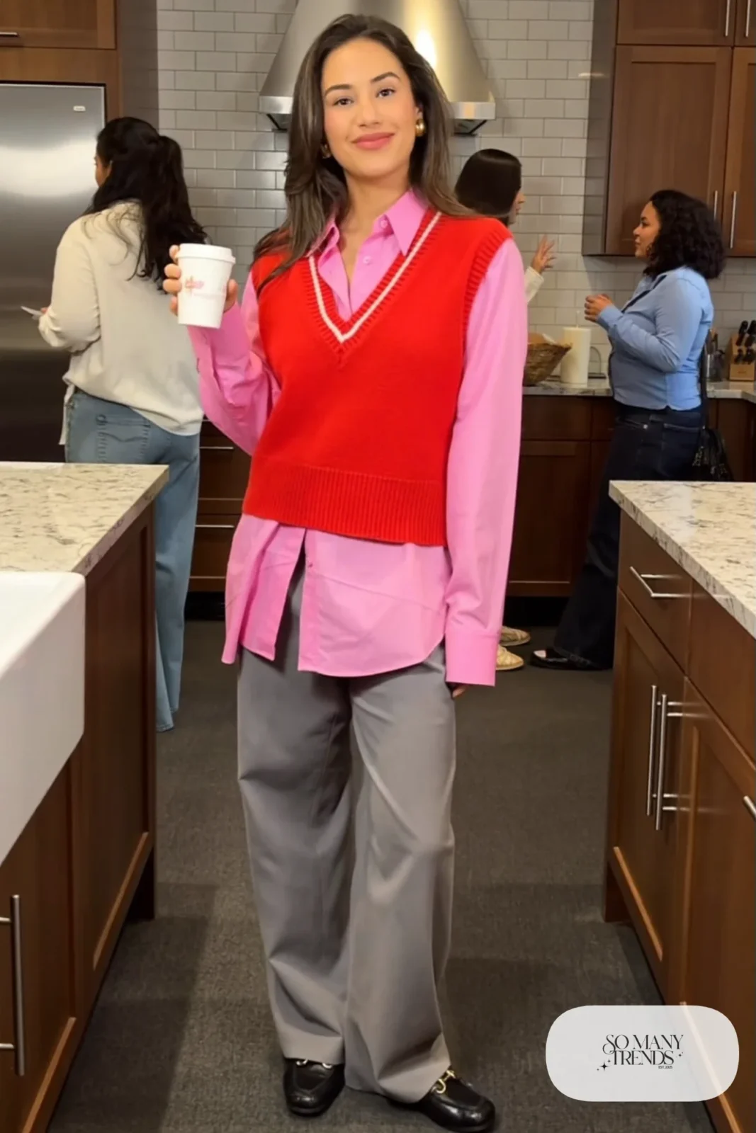 Woman in a red knit vest over a pink poplin shirt with gray wide-leg pants and black loafers, outfit 18