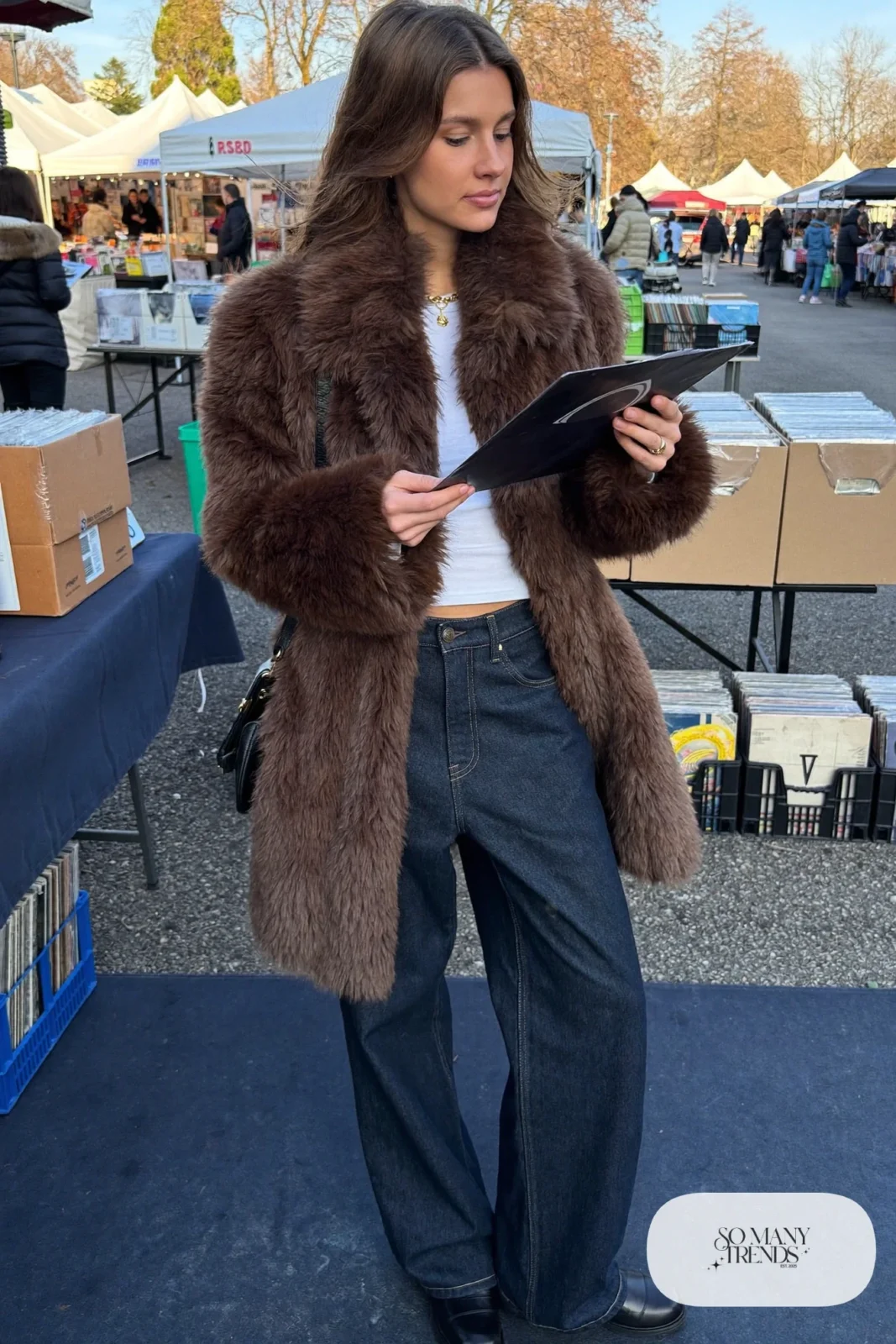 Woman in a chocolate faux fur coat, white fitted tee, wide-leg dark jeans and black boots, outfit 12