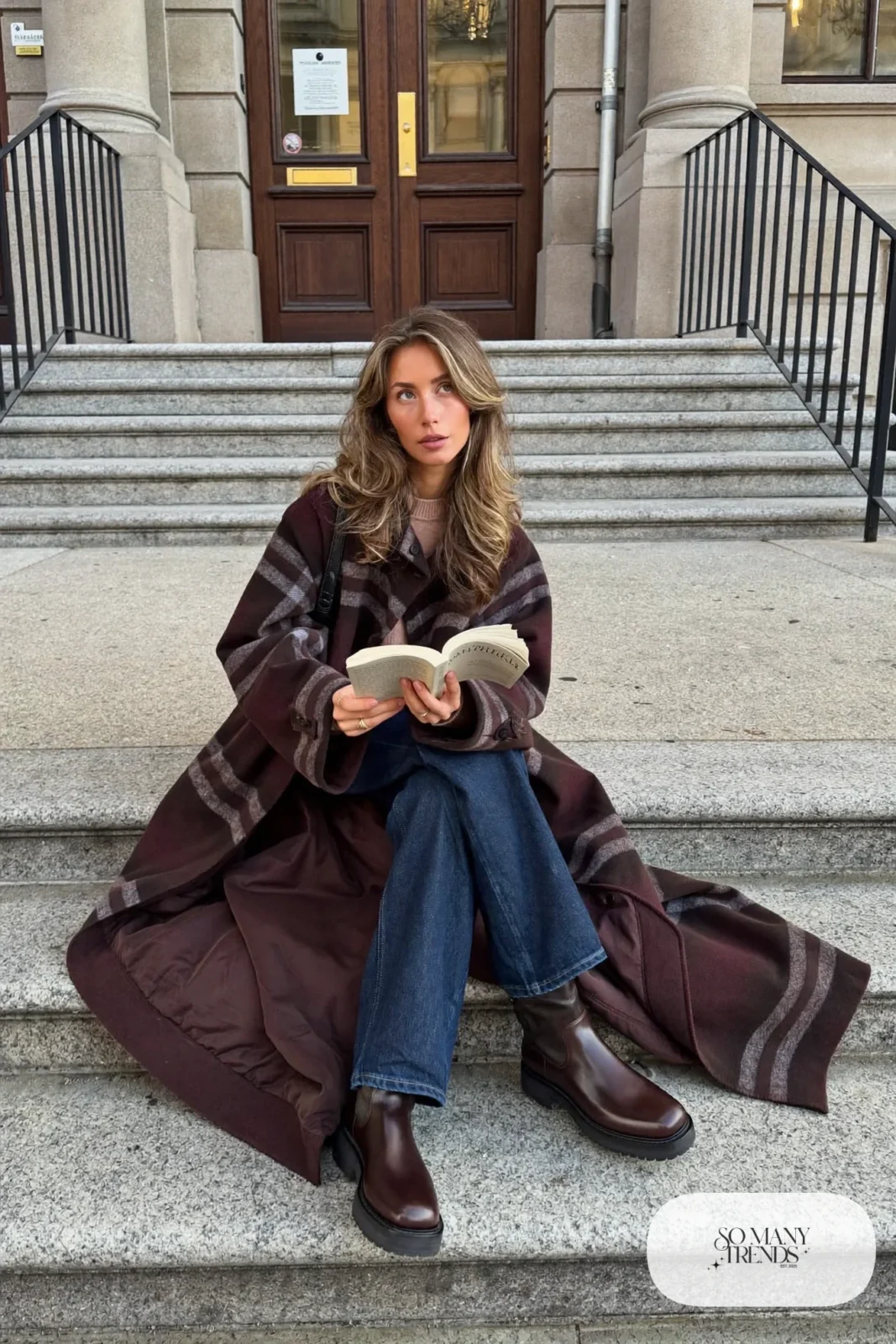 Woman in an oversized plaid blanket coat, blush sweater, straight dark jeans and chunky brown boots, outfit 24