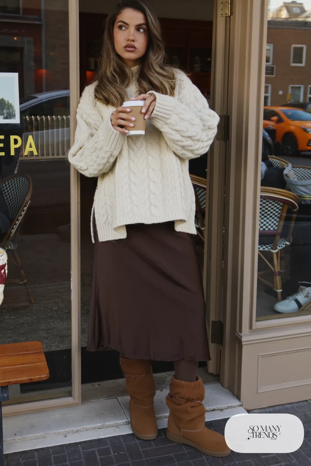 Woman in oversized cream cable-knit sweater, chocolate midi skirt and slouchy tan suede boots, outfit 7