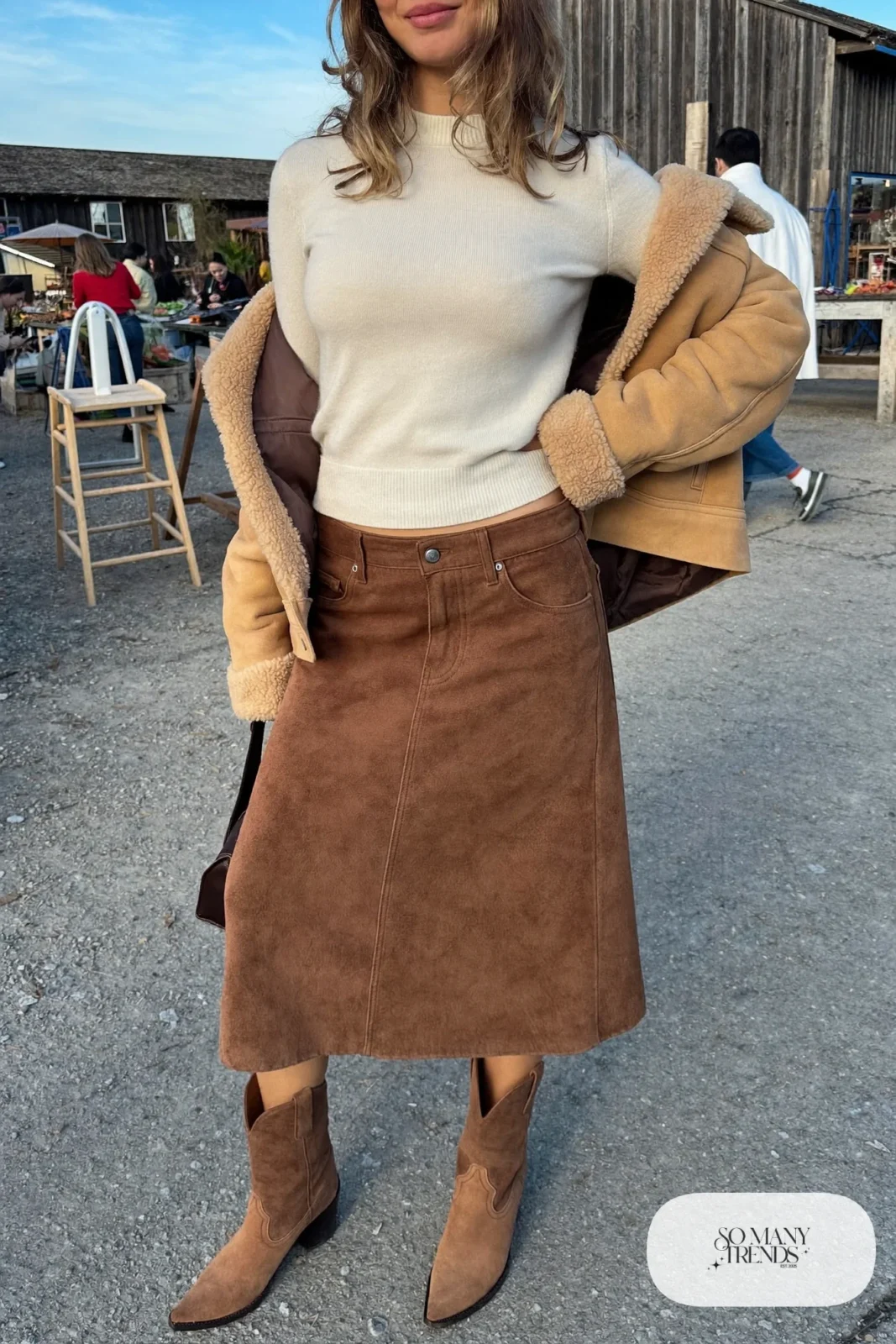 Woman in cream knit, brown suede midi skirt, shearling jacket and western boots, outfit 23