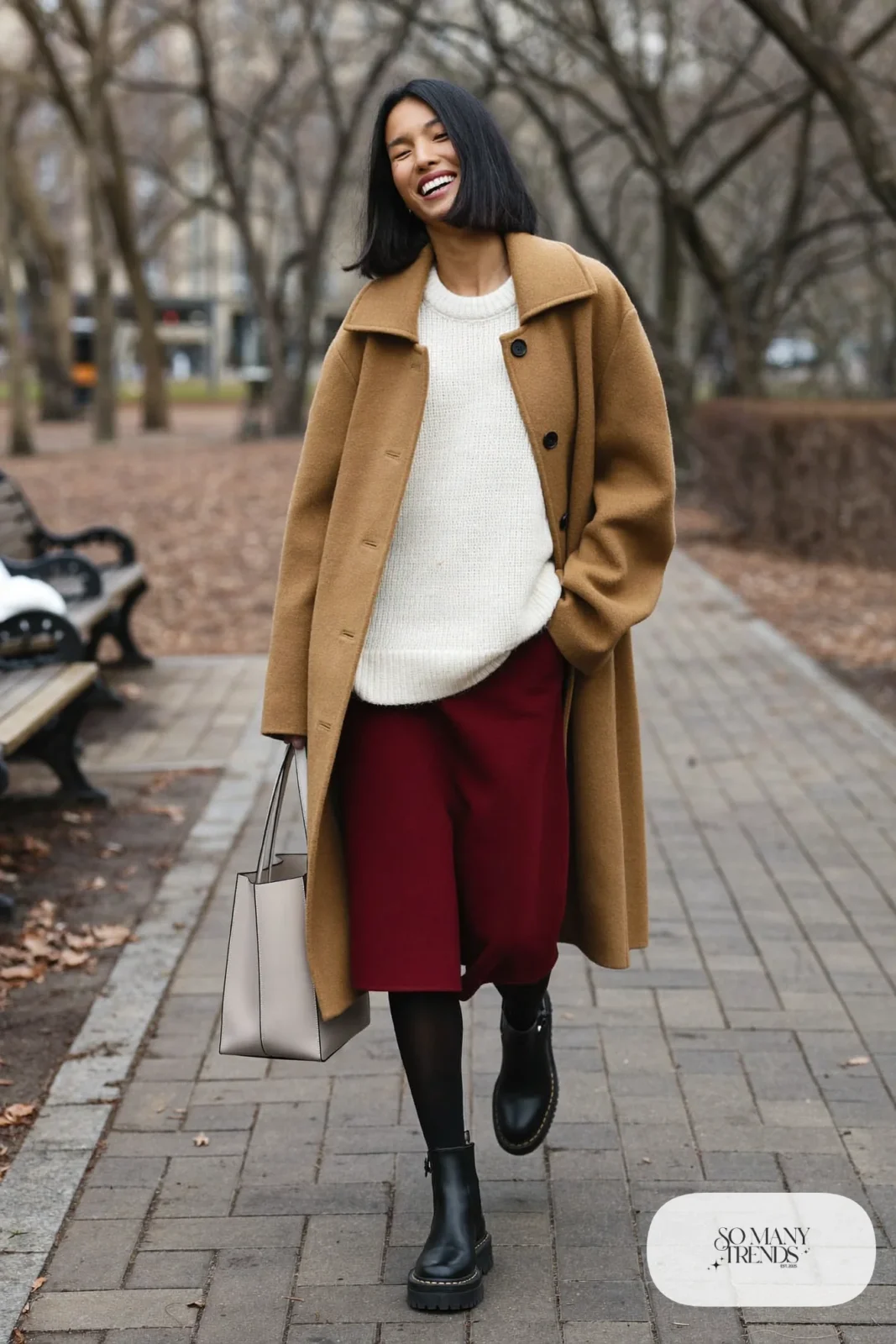 Woman in ivory knit, burgundy wool skirt, camel coat and black lug-sole boots, outfit 27