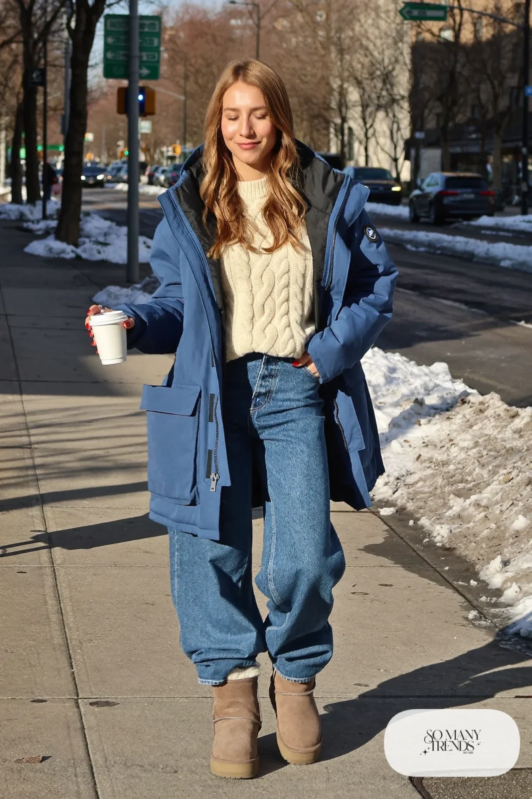 Woman in ink blue hooded parka, cream sweater, wide jeans and shearling-lined boots, outfit 28