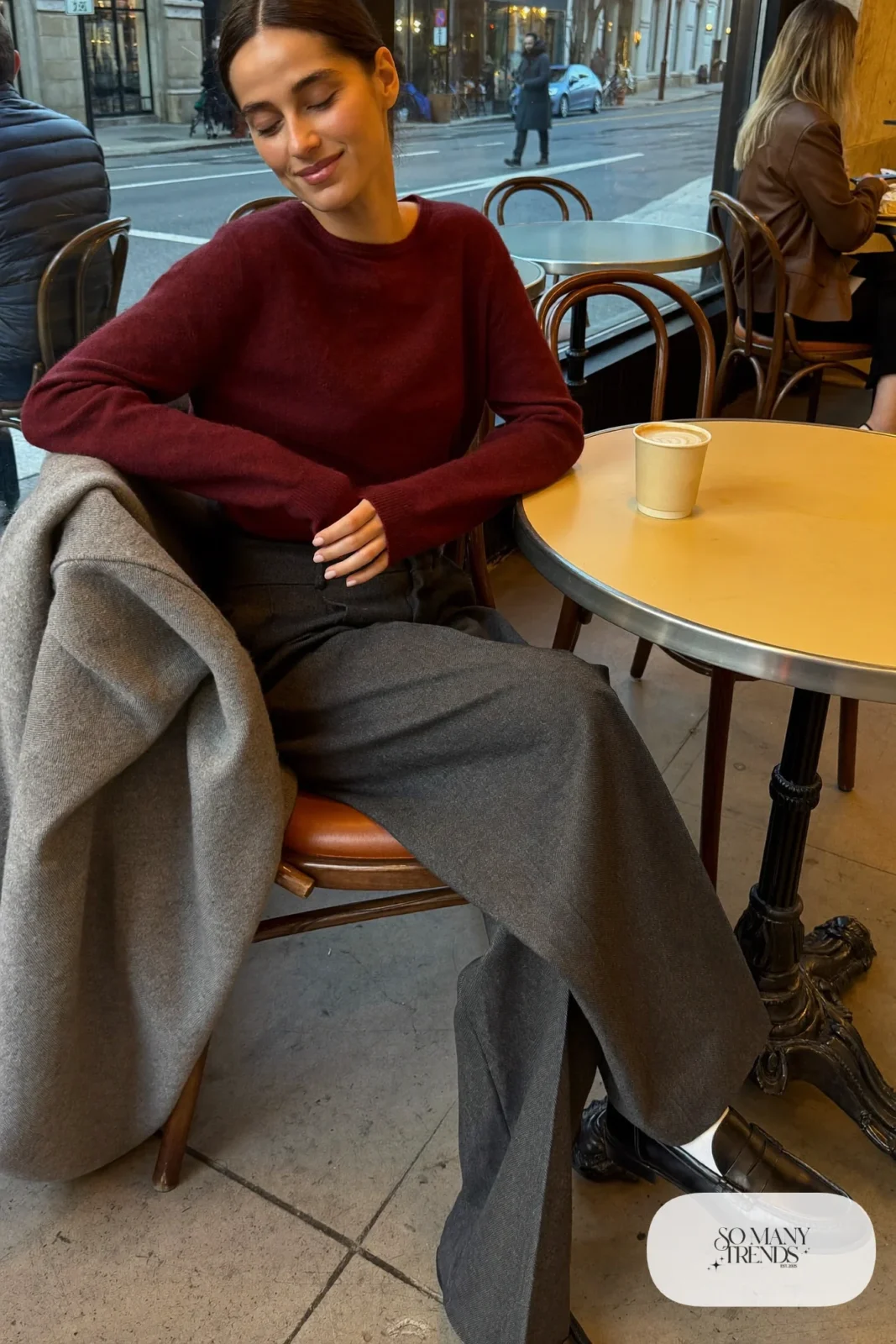 Woman in burgundy merino sweater, charcoal gray wide-leg pants, black loafers and a gray wool scarf, outfit 6