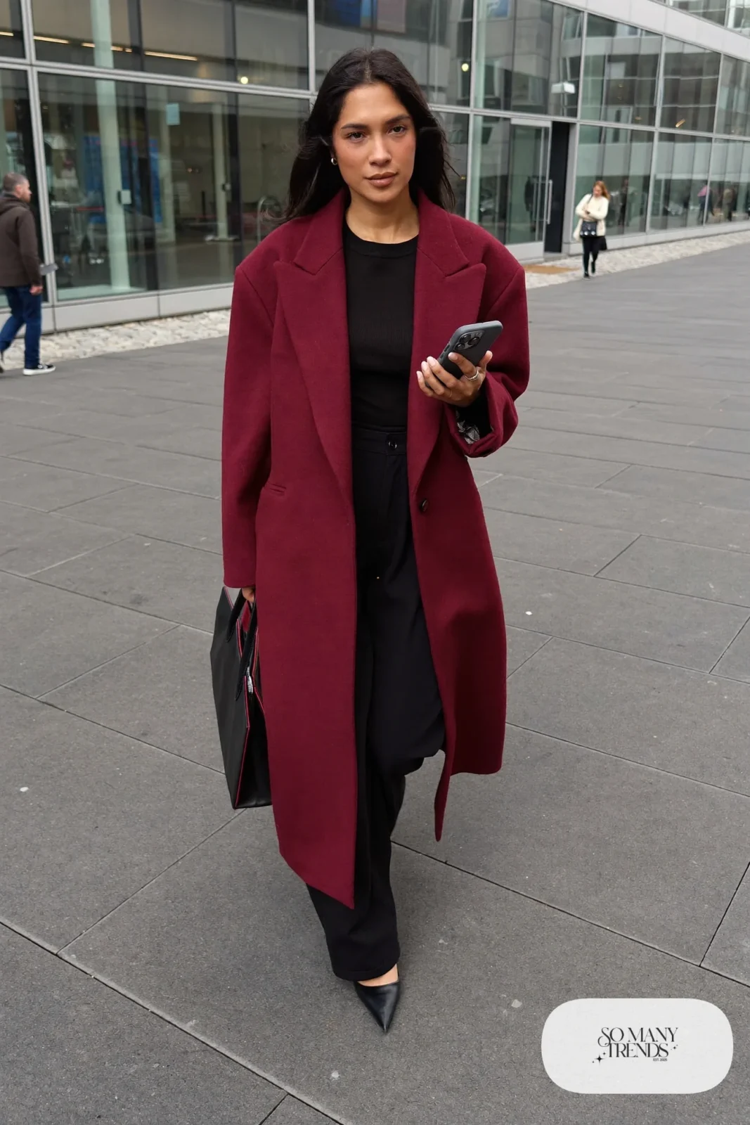 Woman in long burgundy oversized blazer, black fitted top, black wide-leg pants and black pointed pumps, outfit 9
