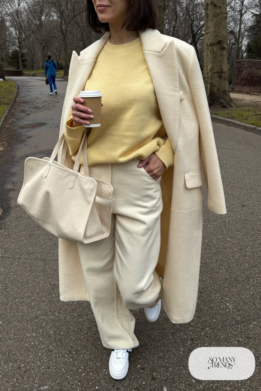 Woman in butter yellow ribbed sweater, cream wide-leg pants, white sneakers and a cream wool coat, outfit 15