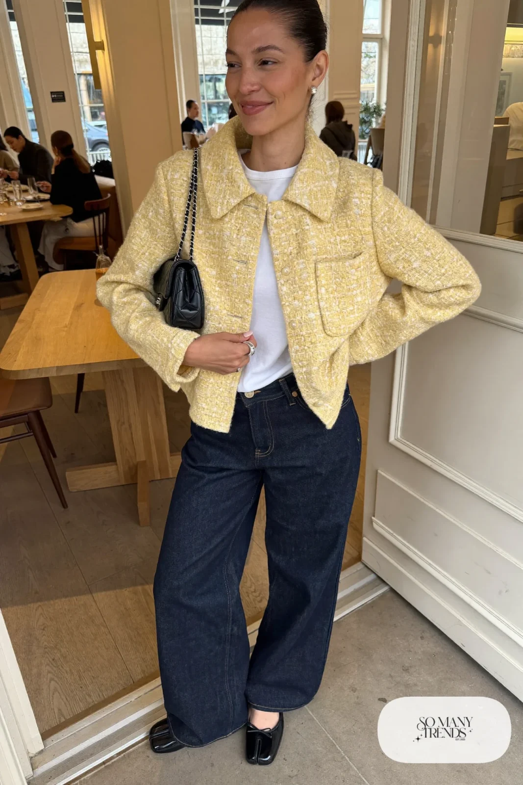 Woman in boxy butter yellow tweed jacket, white tee, dark wide-leg jeans and black ballet flats, outfit 16